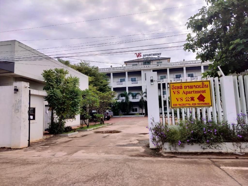 um sinal numa vedação em frente a um edifício em VS appartment em Vientiane