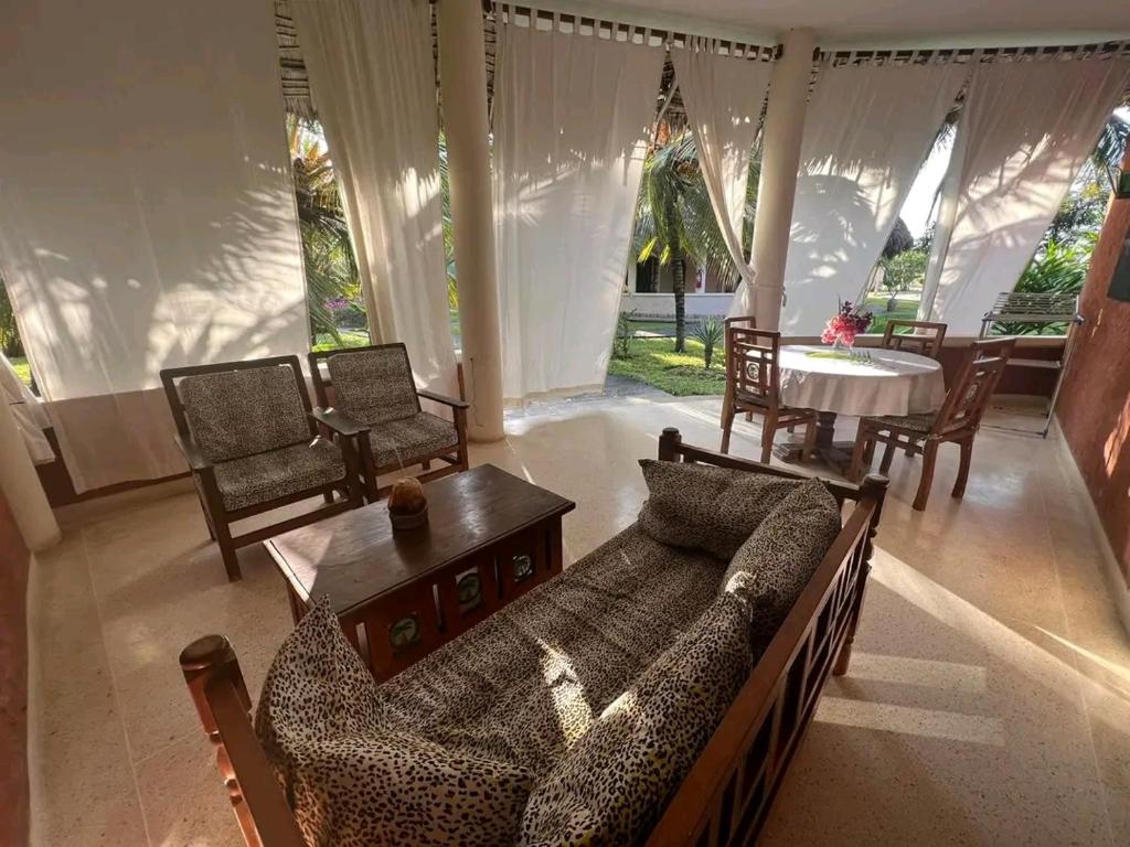 salon z kanapą i stołem w obiekcie Beach front villa in Malindi w mieście Malindi