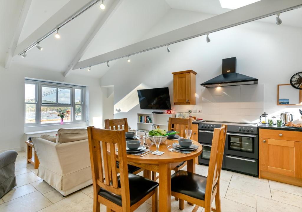 a kitchen and living room with a table and chairs at Gartree Cottage in Fowey