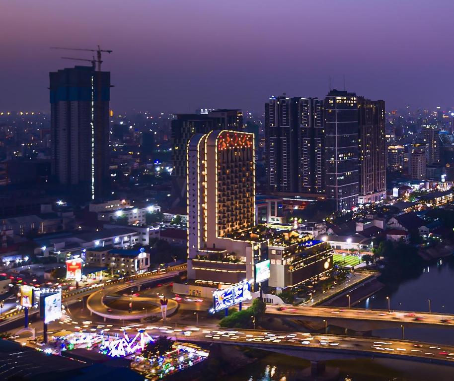 uma cidade iluminada à noite com trânsito em SUN & MOON, Riverside Hotel em Phnom Penh