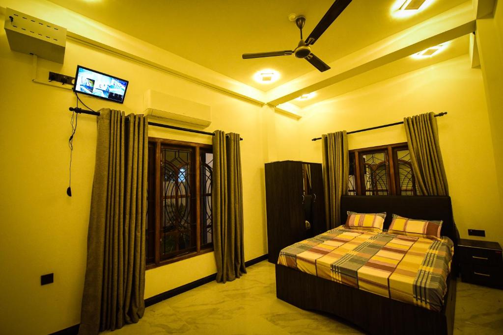 a bedroom with a bed and a television in it at Sai Residence in Jaffna