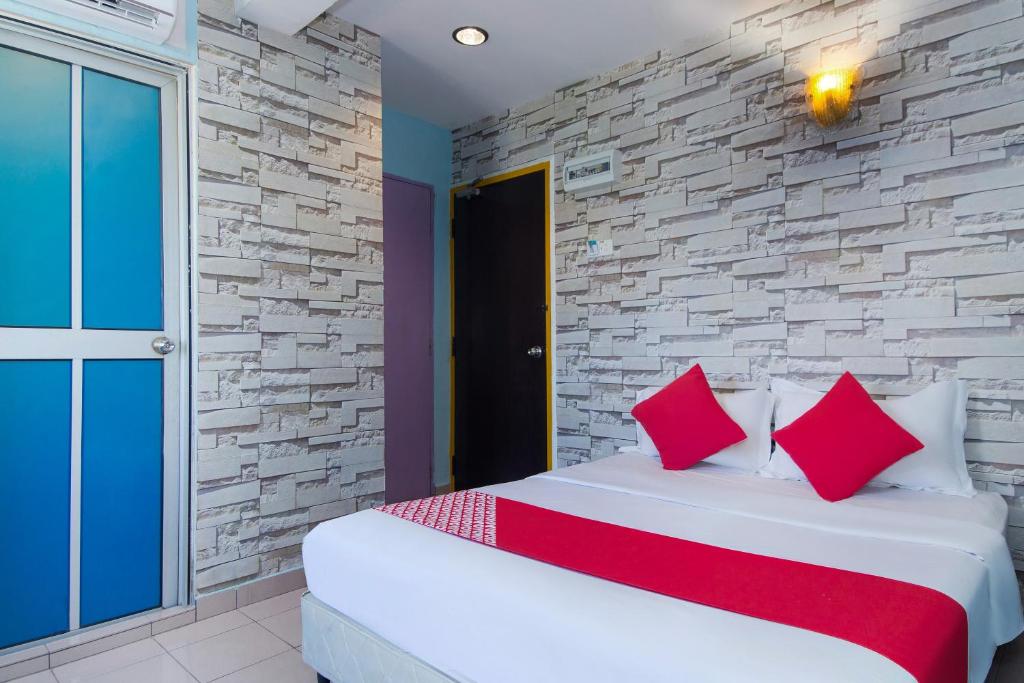 a bedroom with a bed and a stone wall at Lotus Hotel Seremban Near Palm Mall & KPJ Seremban in Seremban