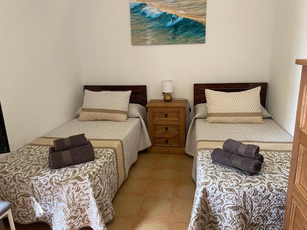 a bedroom with two twin beds and a dresser at Casa Isabel in La Oliva