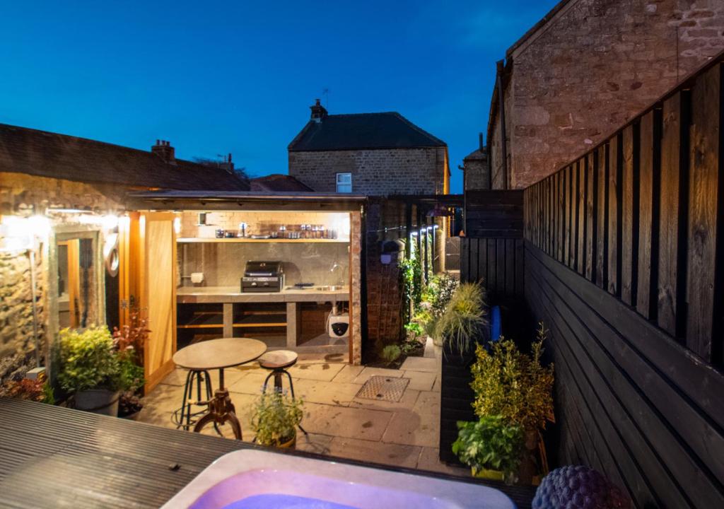 a small backyard with a hot tub on a balcony at Park View Cottage in Kirkby Malzeard