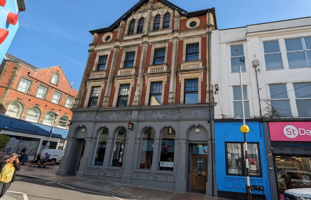 an old building on the corner of a street at Gorgeous comfortable Apartment on the High Street in Merthyr Tydfil