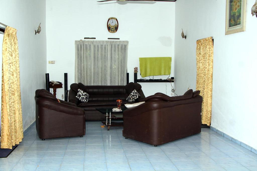 a living room with two leather couches and a couch at Villa Hasi in Habaraduwa Central