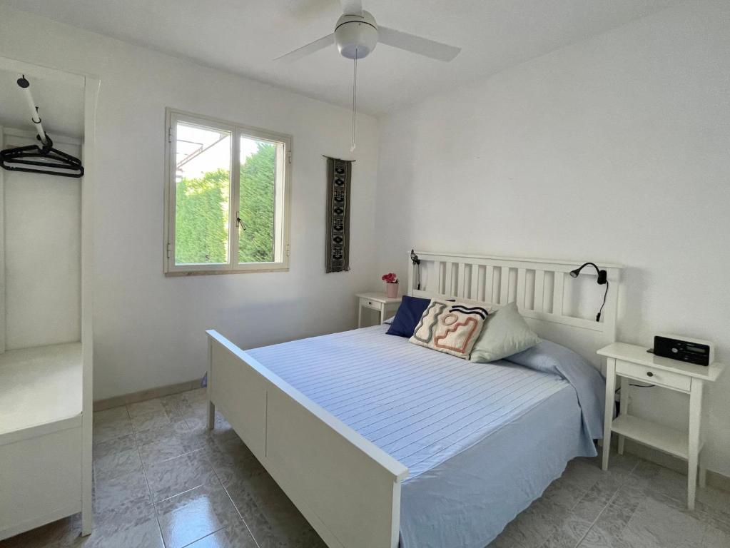 a white bedroom with a bed and a window at Holiday Home Eurovillage in Torre Lapillo