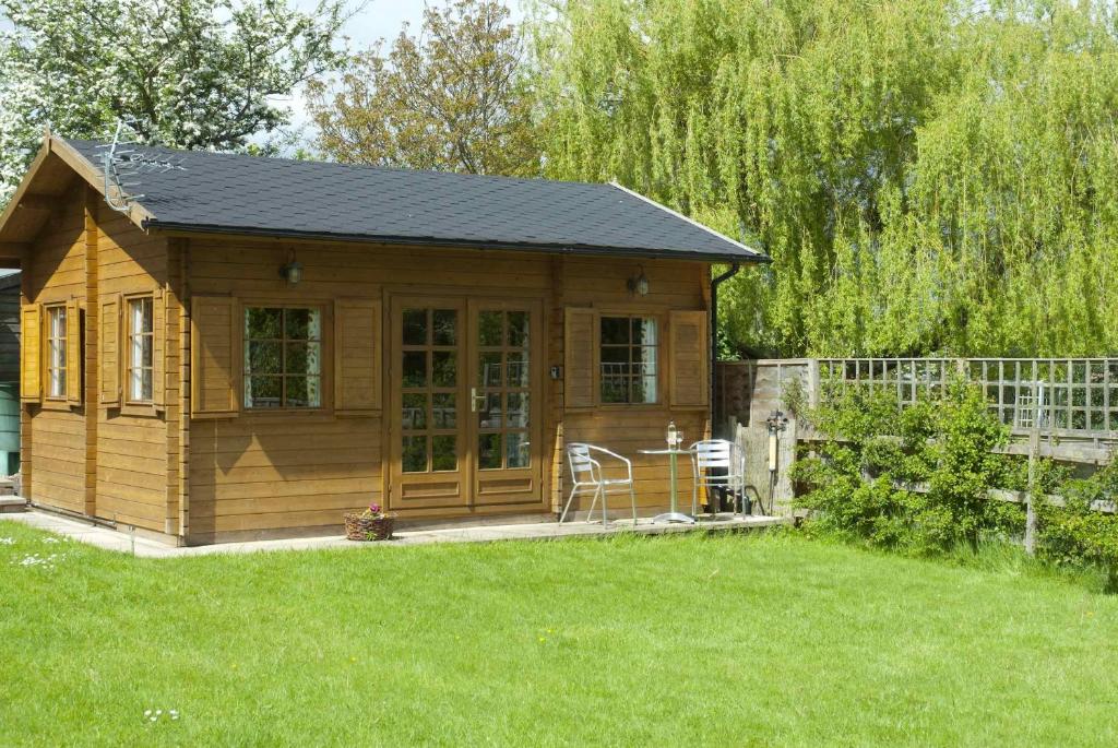 a small cabin with a porch in a yard at ArtHouse B&B in Oakham