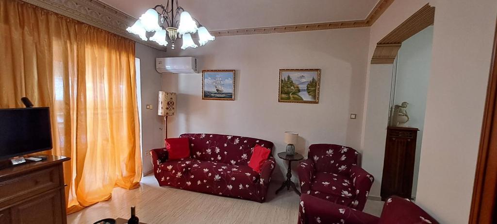 a living room with a red chair and a television at Sq Varnava apartment Athens in Athens