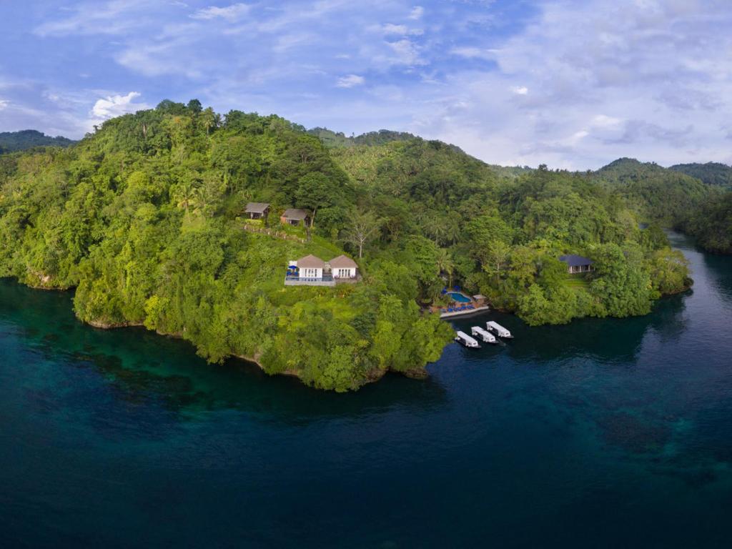 eine Insel mit Häusern und Booten im Wasser in der Unterkunft Lembeh Resort in Bitung