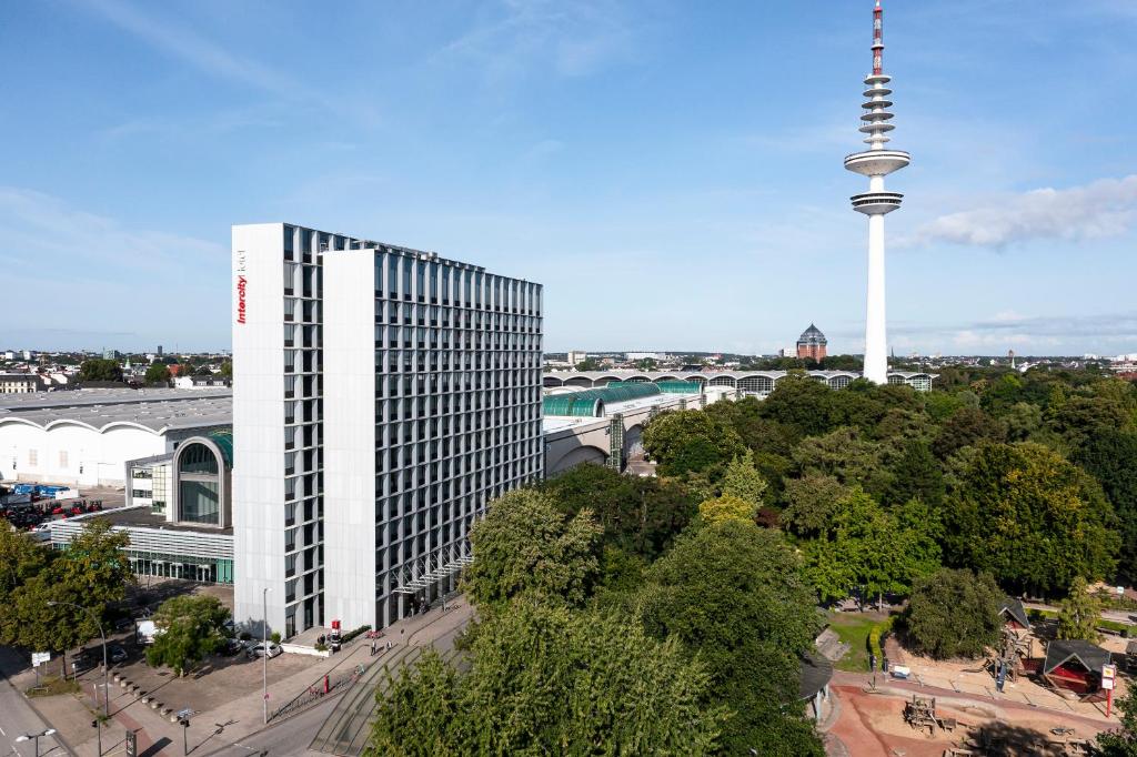 Blick auf ein hohes Gebäude mit einem Turm in der Unterkunft IntercityHotel Hamburg Dammtor-Messe in Hamburg