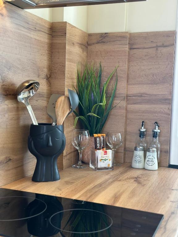 a wooden shelf with wine glasses and a faucet at Vila Arial in Vlorë