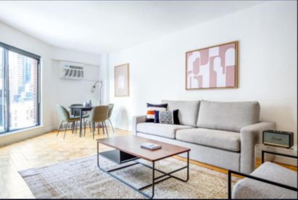 a living room with a couch and a table at Comfortable 3 Bedroom Apartment in New York