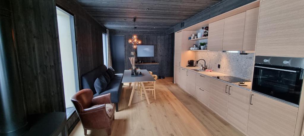 a kitchen with a couch and a table in a room at Kikut Alpin Lodge - Ski in, Ski out in Geilo