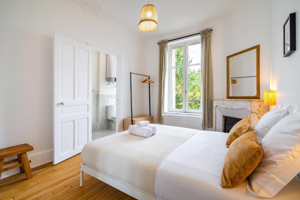 - une chambre blanche avec un lit et une cheminée dans l&#39;établissement Le Chic de Medreville * Nancy, à Nancy