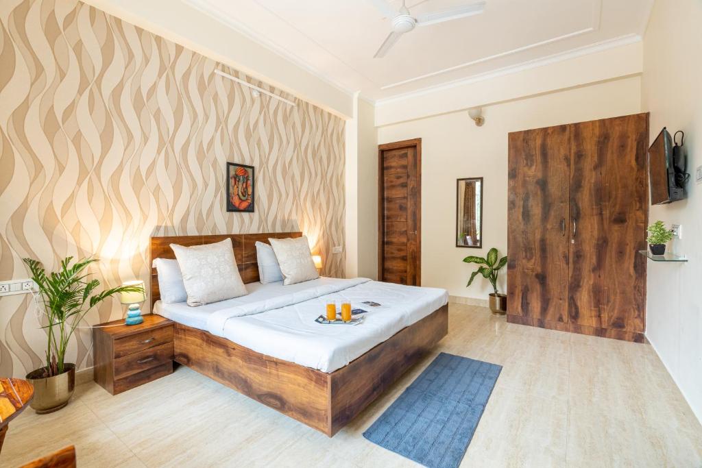 een slaapkamer met een bed met een houten hoofdeinde bij Homlee - Hill View Apartment Luxury in Rishīkesh