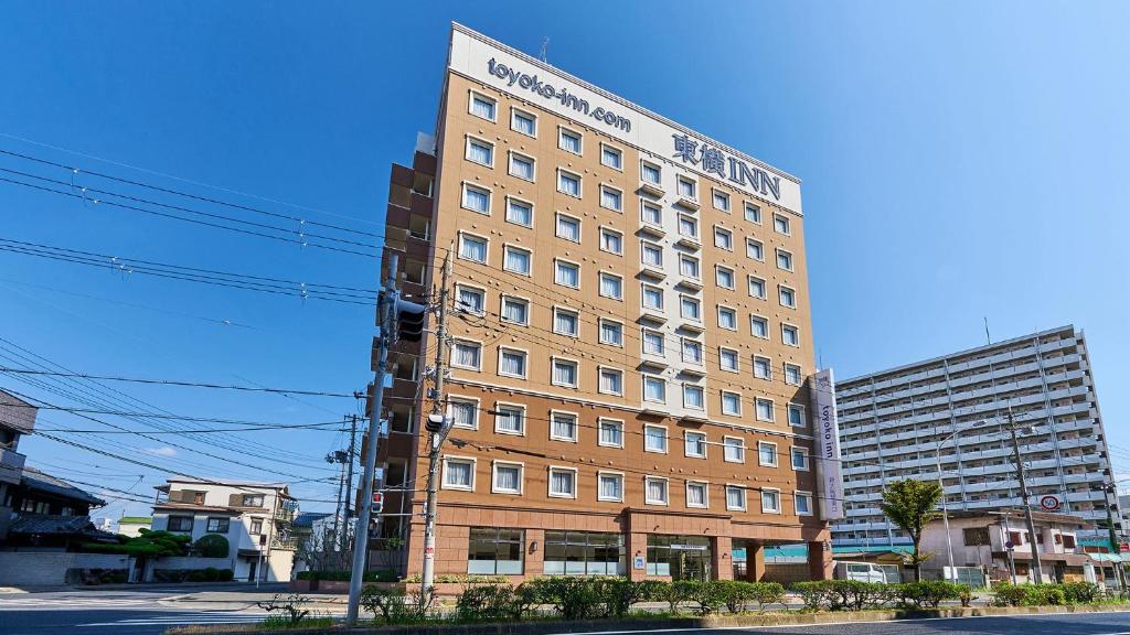 een hoog bakstenen gebouw op de hoek van een straat bij Toyoko Inn Shin-Osaka-eki Higashi-guchi in Osaka