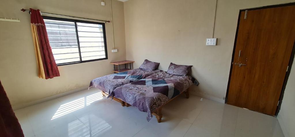 a bedroom with a bed and a window at Galaxy Residency in Aurangabad