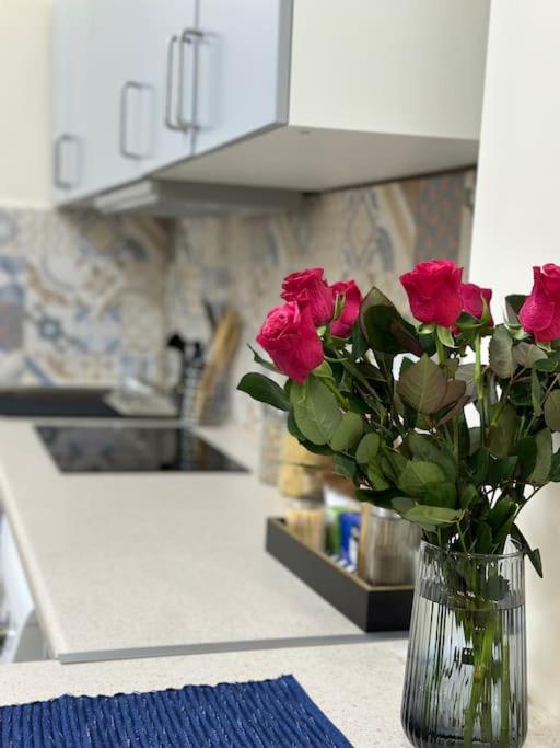 a vase of roses sitting on a counter in a kitchen at Kleparski 17 Apartament in Krakow