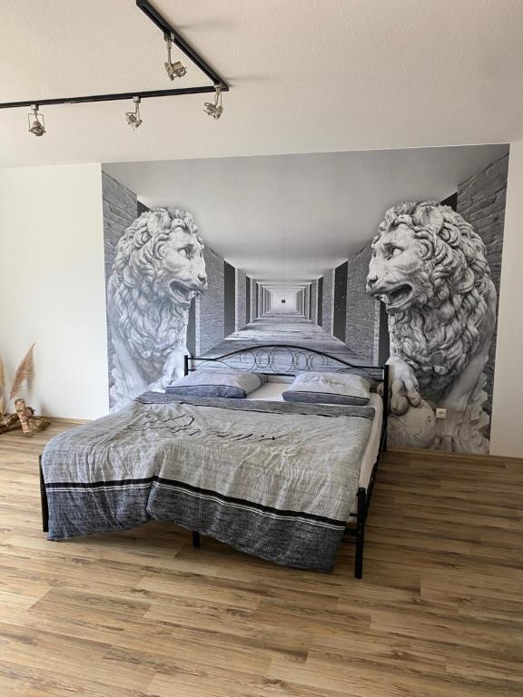 1 dormitorio con 1 cama con leones en la pared en Ferienwohnung im Herzen von Weiden en Weiden