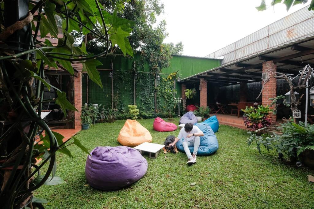 a group of people sitting on bean bags in a yard at Rumah Canda in Bandung