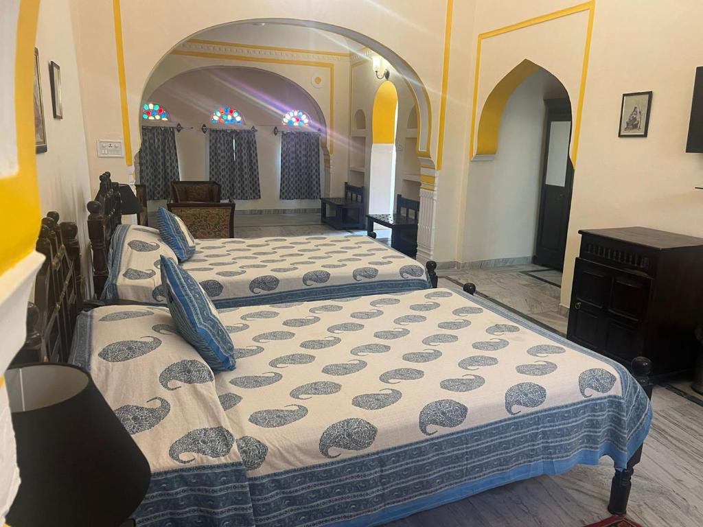 um quarto com duas camas num quarto em hotel castle alsisar em Alsīsar