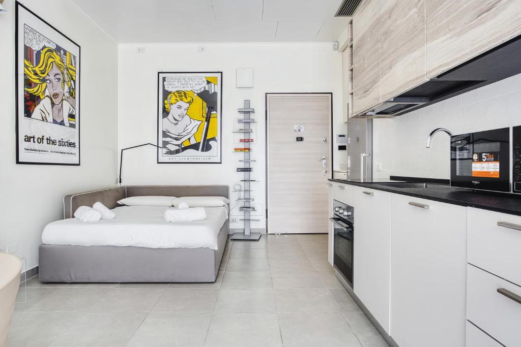 uma cozinha branca com uma cama num quarto em JOIVY Welcoming Studio near CityLife em Milão