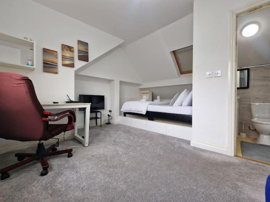 een slaapkamer met een bed, een bureau en een stoel bij Nice Living Serviced Accommodations 9 (King-Size Studio Flat + Kitchen) in Coventry