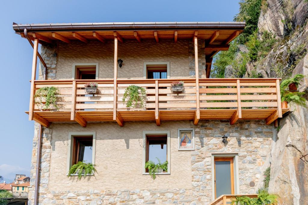 a building with a balcony on the side of a mountain at Green Chalet Scalotta - Nature Relax Lake View in Dervio