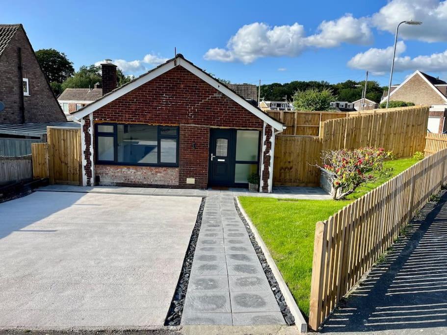 een huis met een oprit en een hek bij Modern bungalow in good location in Aberdulais