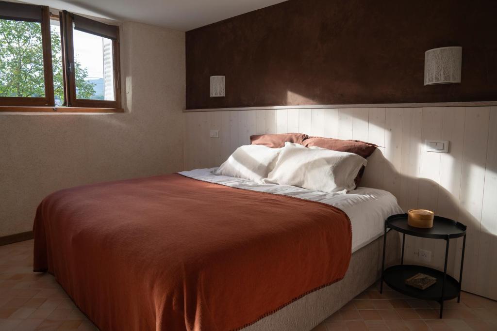 a bedroom with a large bed with orange and white pillows at Charmant Appartement T2 Parking & Terrasse - Crêt de la Roche in Aix-les-Bains