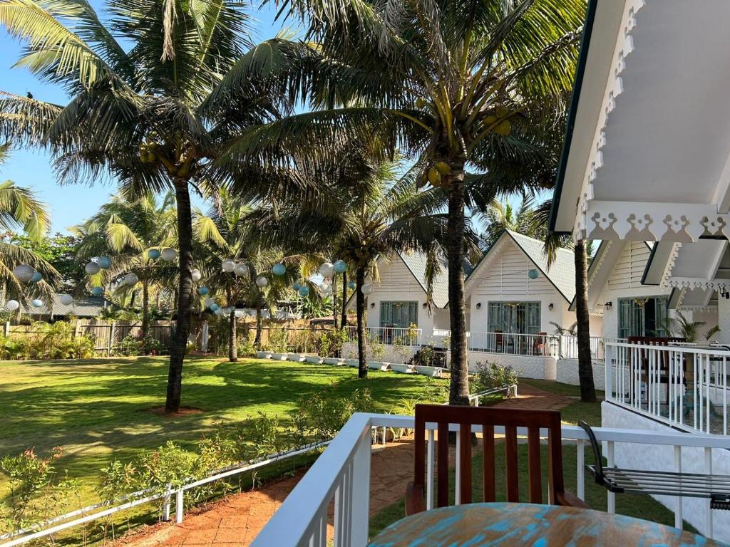 een uitzicht vanaf het balkon van een huis met palmbomen bij S2 Beach Cottages in Morjim