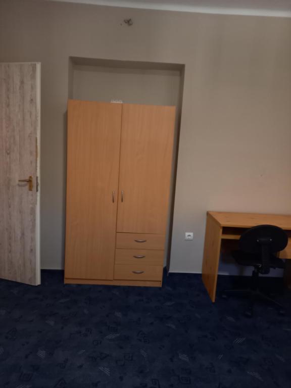 um quarto vazio com uma secretária e um armário de madeira em Spacious home em Gödöllő