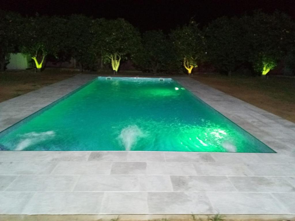 a swimming pool lit up at night at Finca Azahar Chipiona in Chipiona