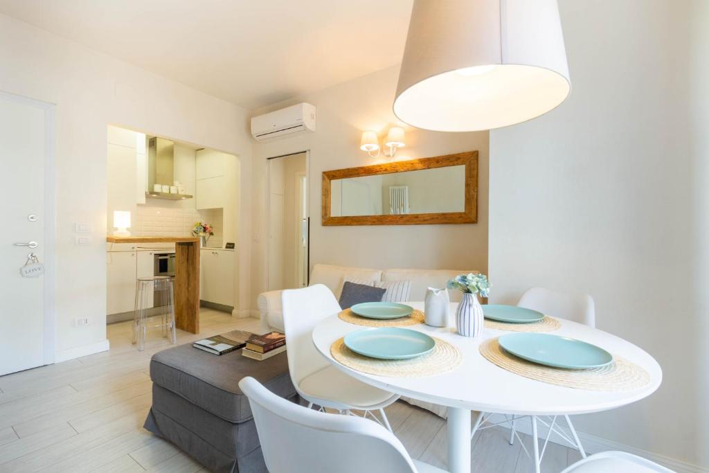 comedor y sala de estar con mesa blanca y sillas en Appartamento Garbino Deluxe - MyHo Casa, en Marina Palmense