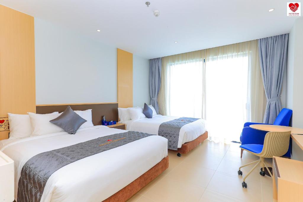 um quarto de hotel com duas camas e uma janela em Victor Group Condotel Cam Ranh em Cam Lâm