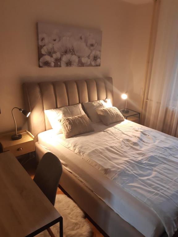 una camera da letto con un grande letto con due cuscini di Verde 1 a Šabac