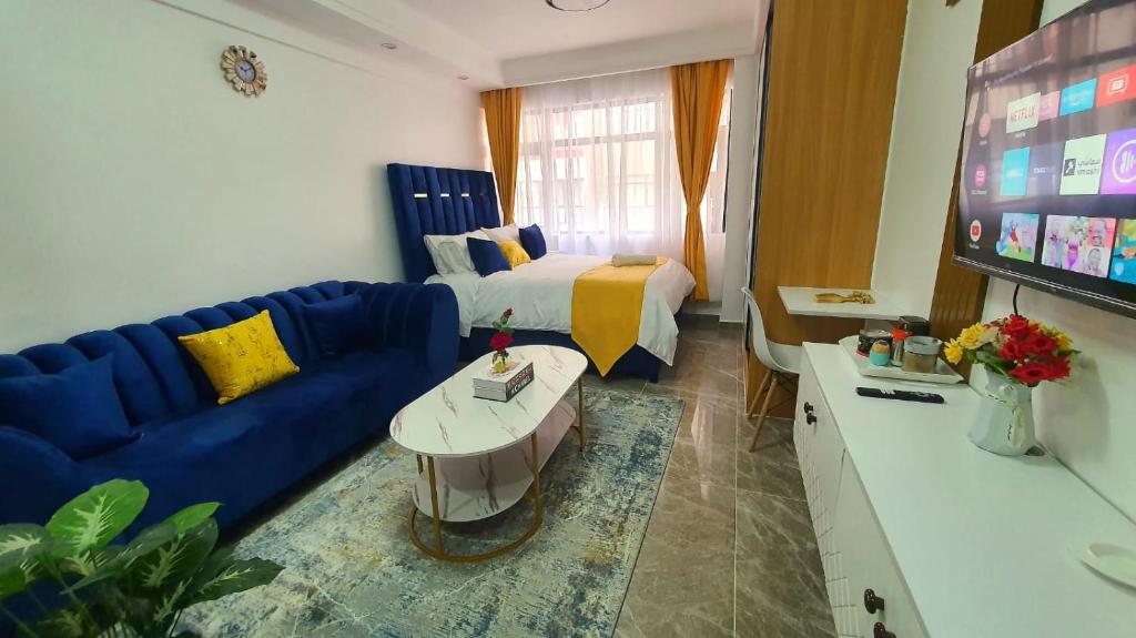 ein Wohnzimmer mit einem blauen Sofa und einem Bett in der Unterkunft Hasbi in Nairobi