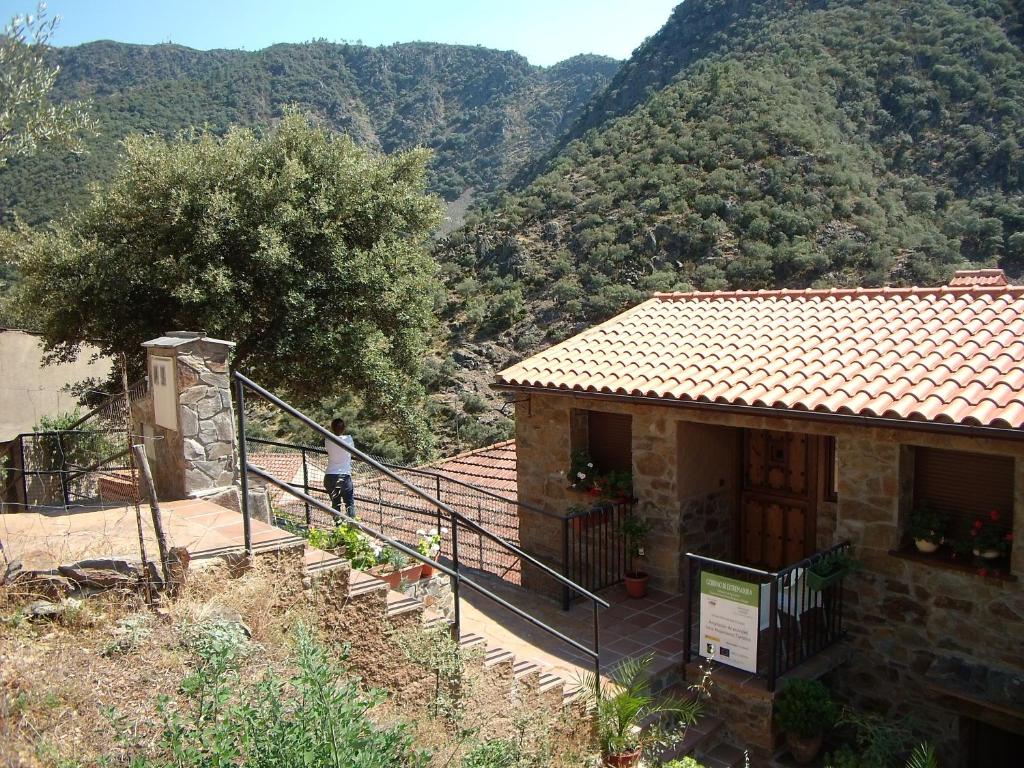 una casa con una escalera junto a una montaña en Las Casitas Del Bodegon, en El Gasco