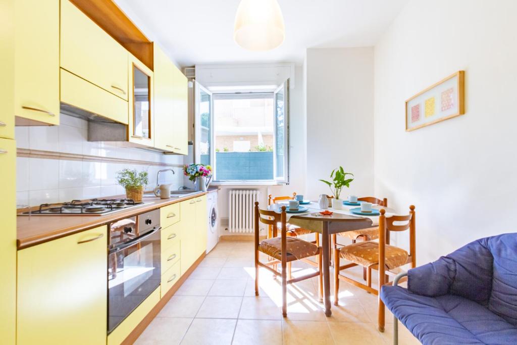 cocina y comedor con mesa y sofá en Appartamento Bellariva PT - MyHo Casa, en Porto San Giorgio