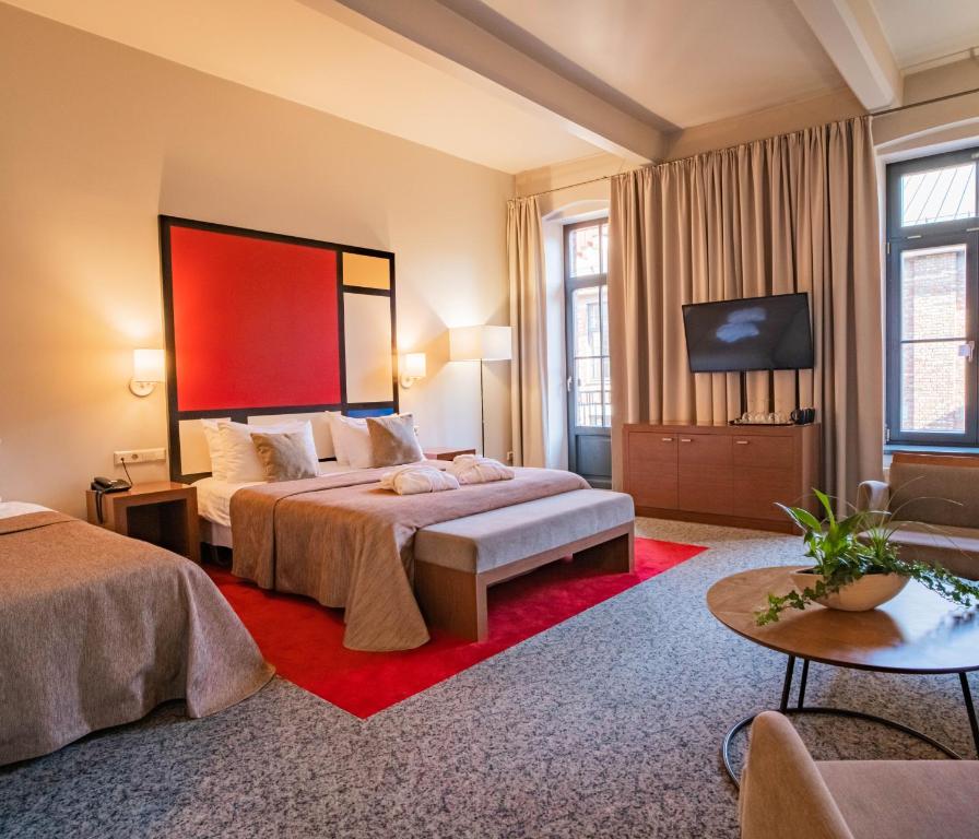 カウナスにあるVICTORIA Hotel Kaunasのベッド2台、薄型テレビが備わるホテルルームです。