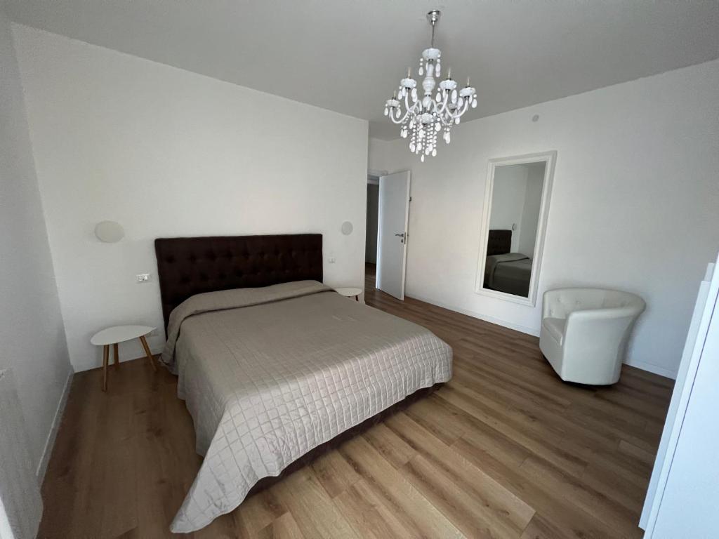 Un dormitorio con una cama grande y una lámpara de araña. en Ca’ Uccelli-Stupendo Appartamento 5 min da Venezia en Marghera