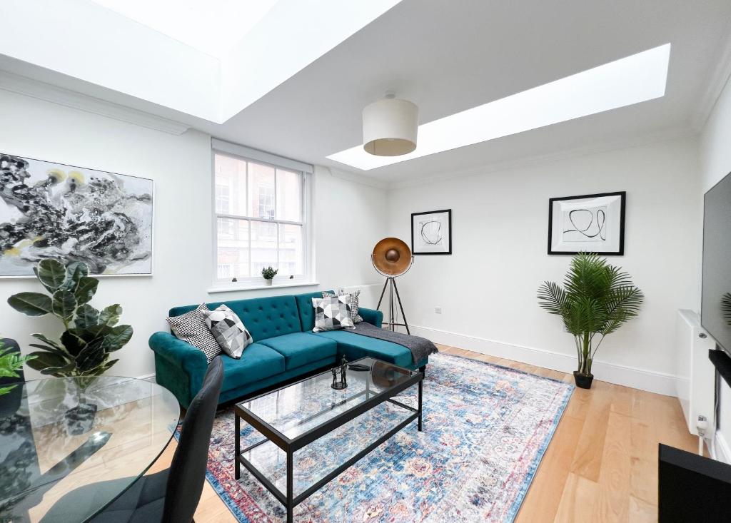 uma sala de estar com um sofá azul e um tapete em Museum ST Central Soho Apartment em Londres