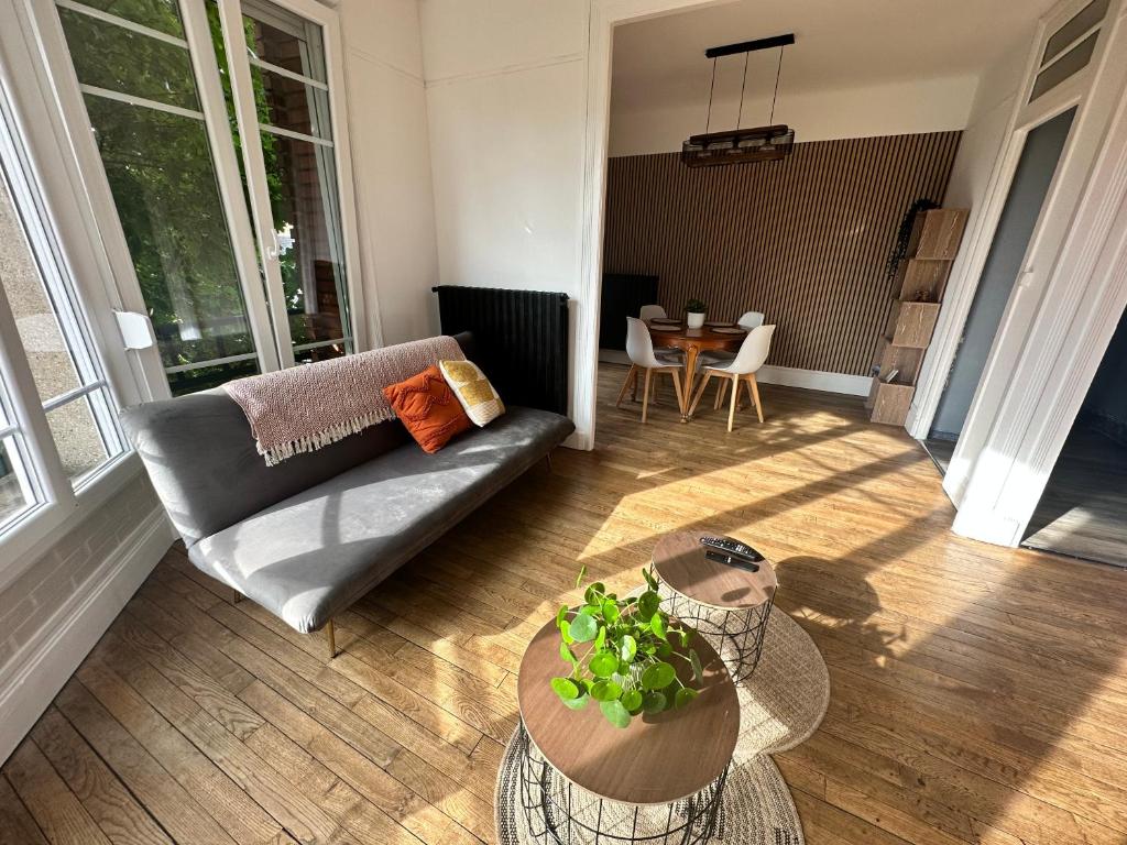 un salon avec un canapé et une table dans l'établissement Appartement lumineux et spacieux, à Charleville-Mézières