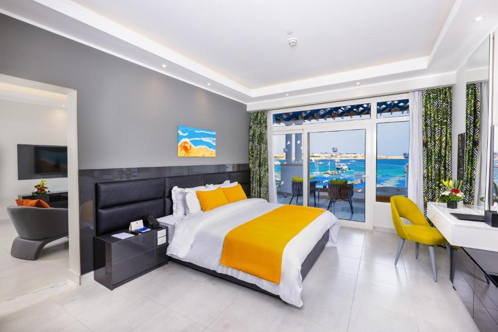een slaapkamer met een bed, een bureau en een wastafel bij Naama Bay Suites & SPA in Sharm El Sheikh