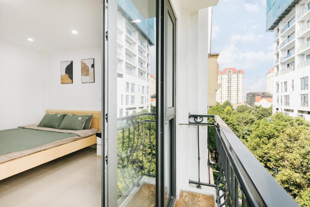 einen Balkon mit einem Bett und einem Fenster in der Unterkunft 9 LIGHT APARTMENT in Hanoi