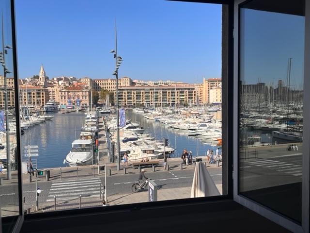een uitzicht vanuit een raam op een jachthaven met boten bij T4 Marseille Vue imprenable sur Vieux Port in Marseille