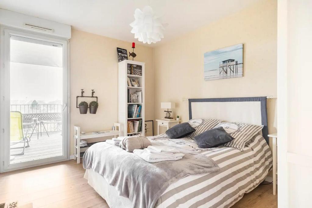 - une chambre avec un grand lit et des draps rayés dans l'établissement Location chambre privée avec salle de bain et WC privatifs dans appartement moderne, à Nantes