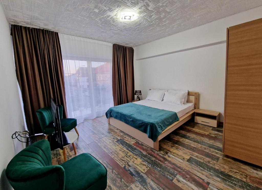 a bedroom with a bed and a chair and a window at 5 Bedrooms Luxury Apartment Villa in Bucharest