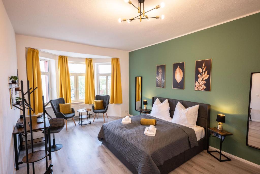a bedroom with a bed and chairs in a room at Loh9 - Das Apartment im Citycenter - Parkplatz - Wlan - Aufzug in Chemnitz